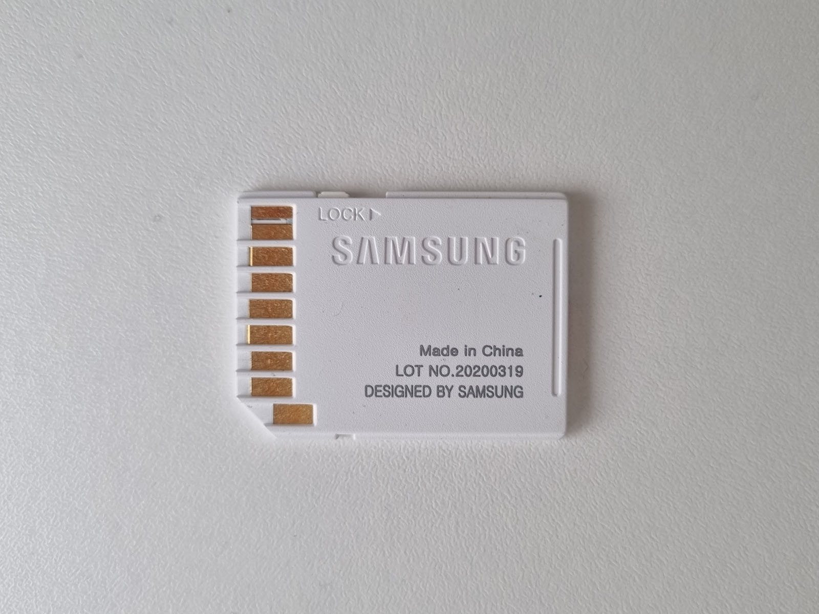 Back of a genuine Samsung SD adapter for microSD cards, showing its printed branding and lot number.