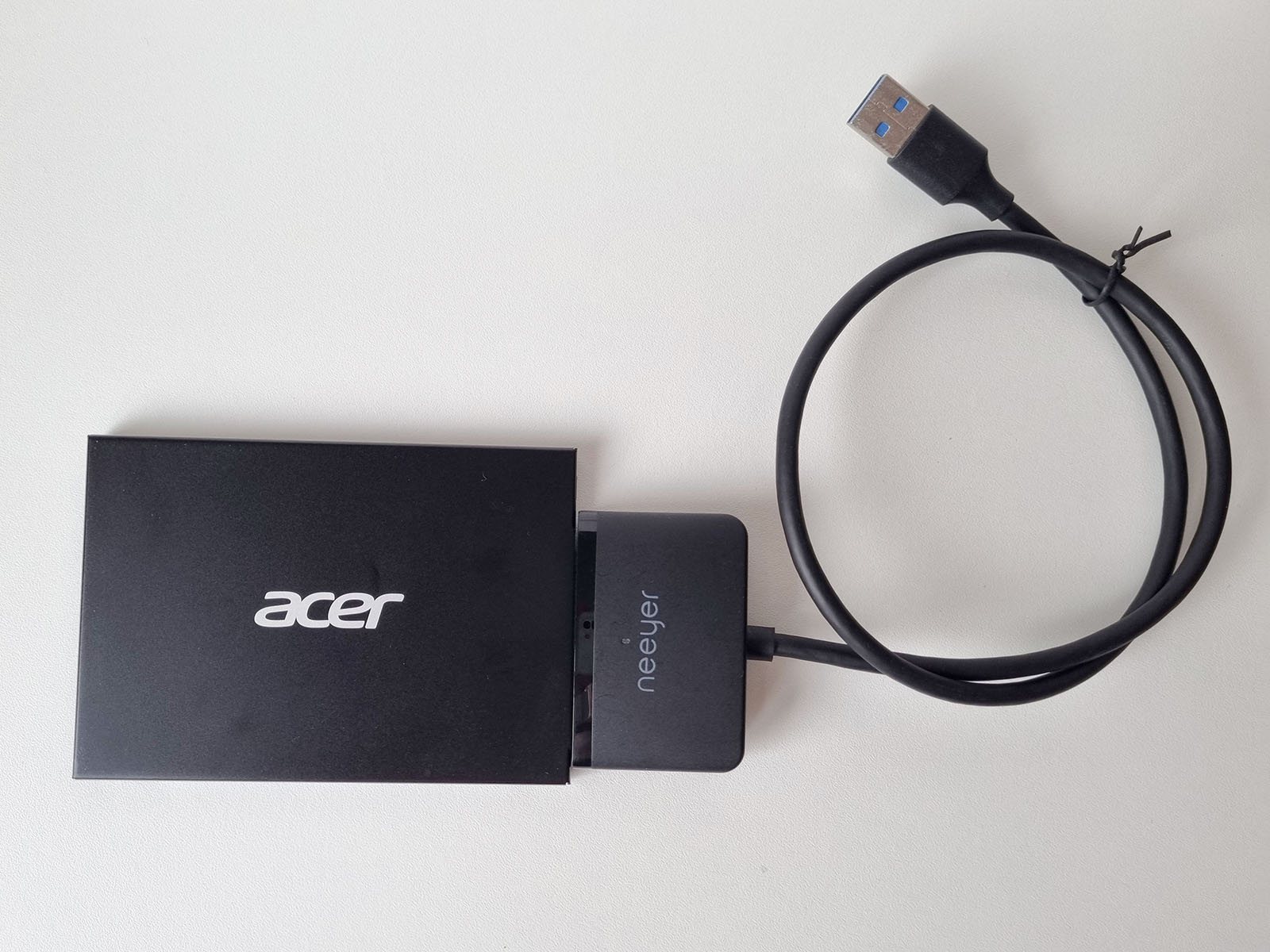 A USB-to-SATA adapter cable connected to a 2.5in hard drive, with its USB 3.0 end ready to plug into another computer.